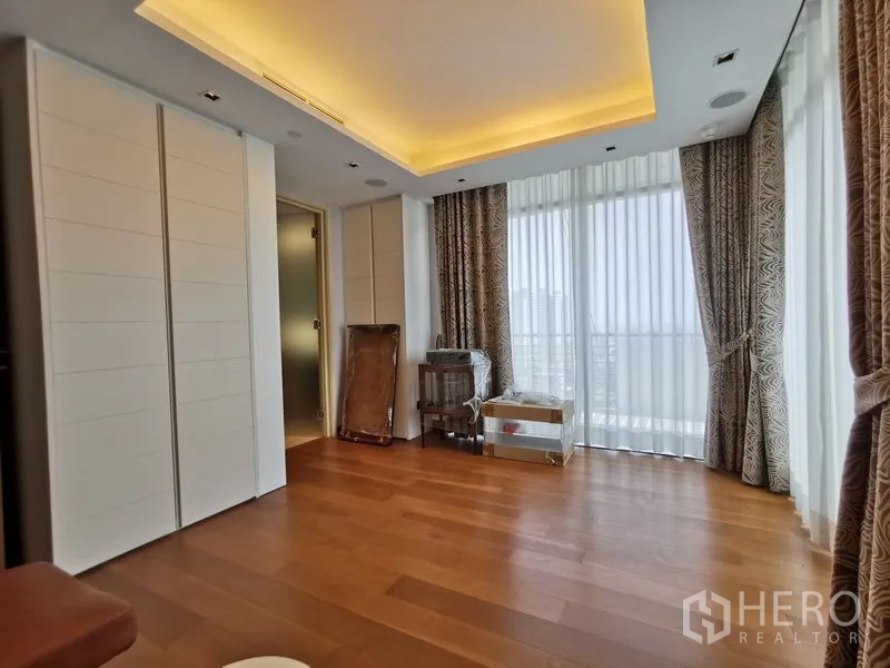 Condominium for rent or sale in Phaya Thai, Bangkok - Bedroom with full-height windows, ample wardrobes, and soft cove lighting.