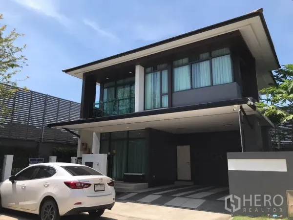 Detached House for rent in Bang Kapi, Bangkok - Modern two-storey detached house with covered carport and large windows under a clear sky in Bang Kapi, Bangkok.