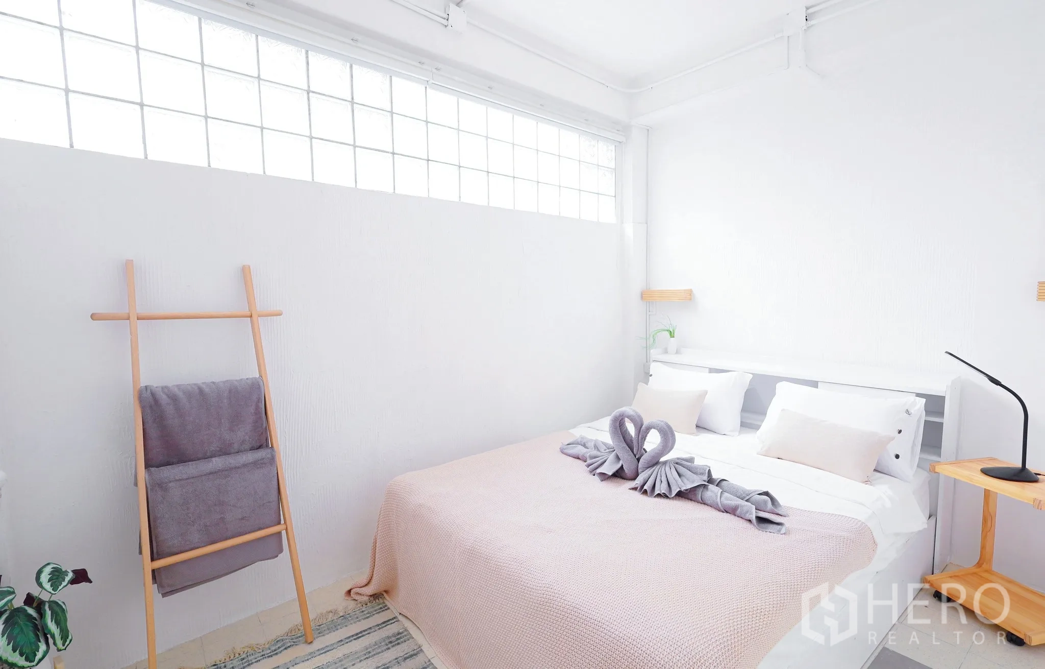 Townhouse for rent in Din Daeng, Bangkok - Compact ground-floor bedroom with frosted glass clerestory windows and soft bedding.