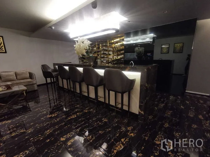 Condominium for rent in Ratchathewi, Bangkok - Elegant residents’ bar with marble island and high stools.
