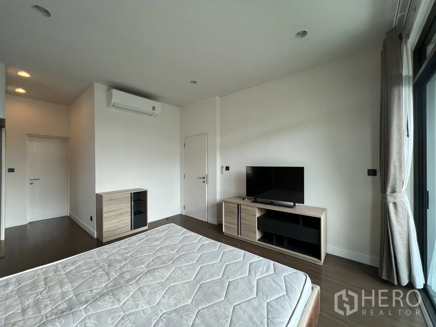 Detached House for rent in Bang Kapi, Bangkok - Master bedroom with TV unit and wide windows.