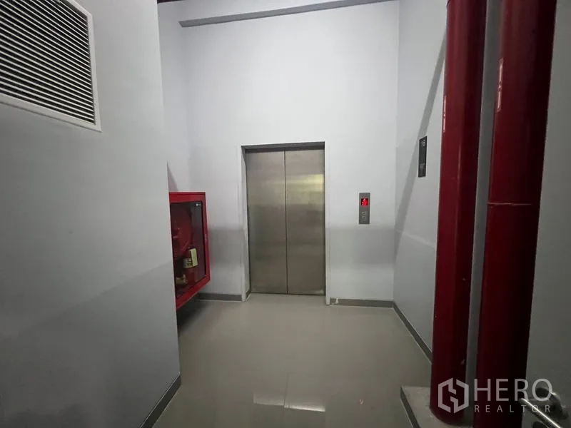 Office Space for rent - Service corridor with a passenger elevator and fire safety equipment.