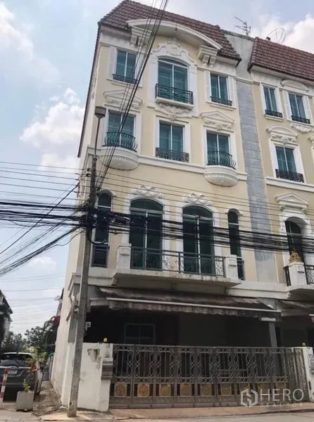 Townhouse for rent in Chatuchak, Bangkok - Multi-storey townhouse exterior with arched windows, small balconies and gated parking in Chatuchak, Bangkok.