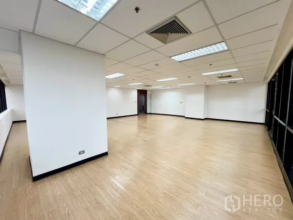 办公空间 出租在Huai Khwang, Bangkok - 开放式办公区，木质地面，周边落地窗，吊顶荧光灯与玻璃入户门。