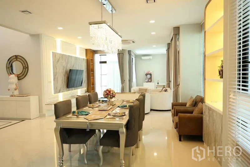 Detached House for rent or sale in Saphan Sung, Bangkok - Open-plan dining and living area with crystal chandelier and marble TV wall.