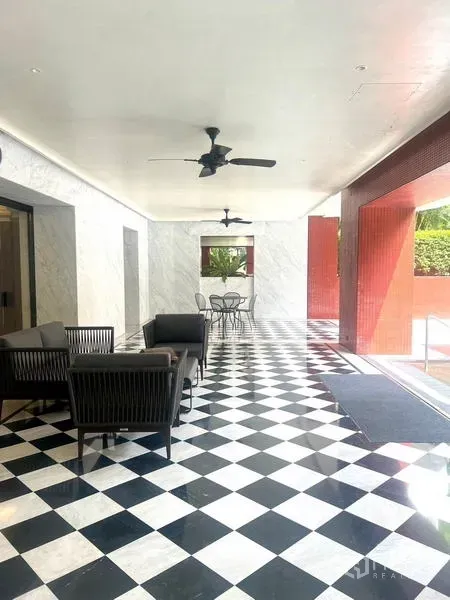公寓 出售在Pathum Wan, Bangkok - 住户有顶休闲区，吊扇与黑白棋盘地面，面向绿意