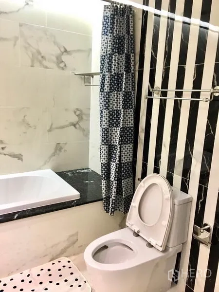 公寓 出租在Watthana, Bangkok - 浴室配浴缸，黑白条纹特色墙与图案浴帘