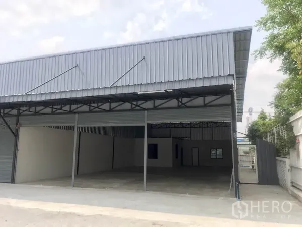 货栈 出租在Pathum Thani - 金属板外立面仓库，卷闸门与遮蔽装卸区一体。