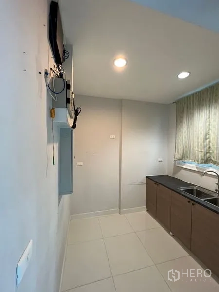 带办公室的家 出租或出售 - 紧凑封闭式厨房，设窗户、水槽与下柜。