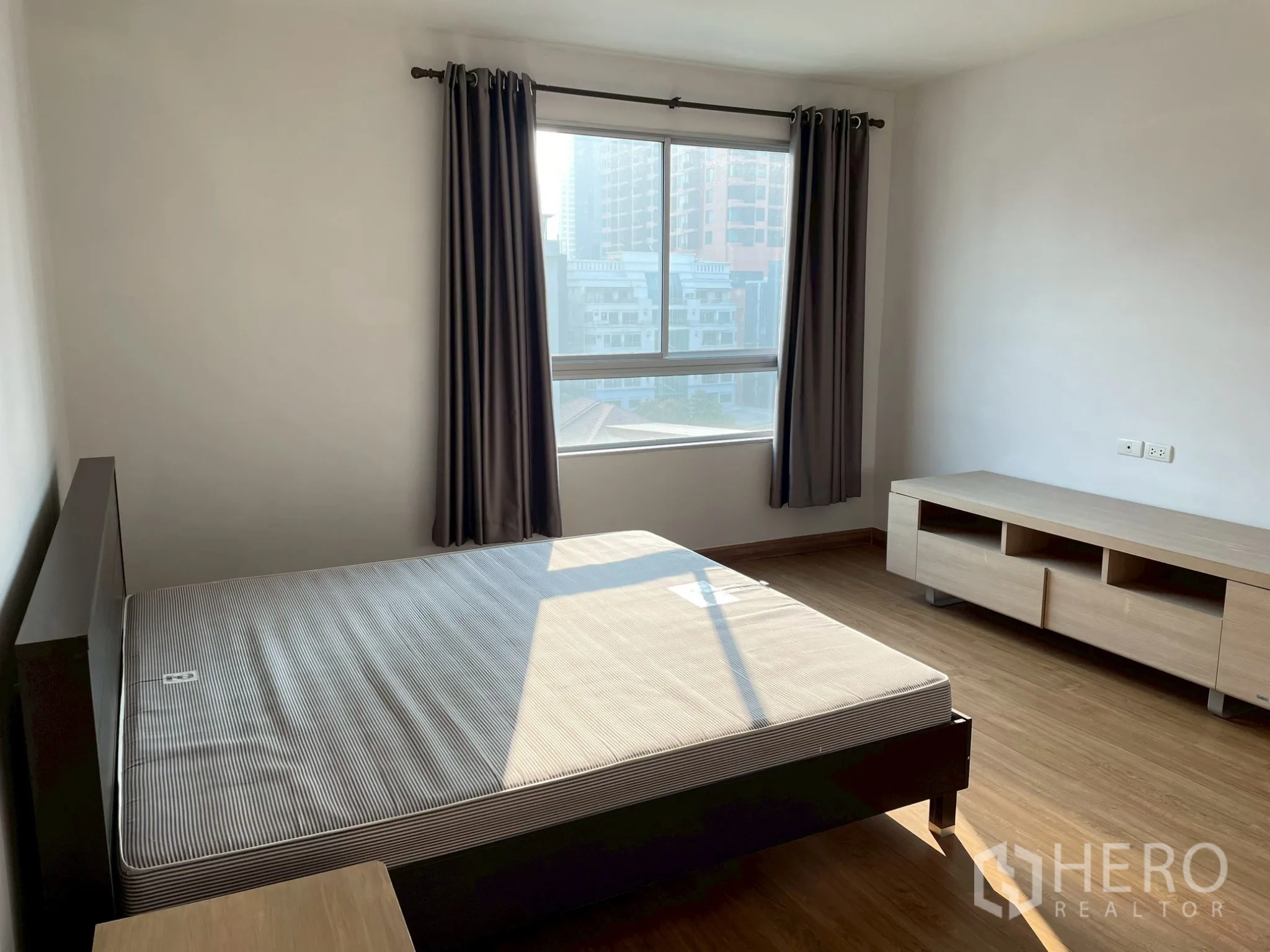 อพาร์ทเมนท์ for rent in Khlong Toei, Bangkok - ห้องนอนรับแสงพร้อมเตียงและหน้าต่างบานใหญ่