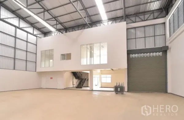 Factory for rent in Phra Nakhon Si Ayutthaya - Warehouse bay with mezzanine office, large automatic roller shutter door and bright loading area.