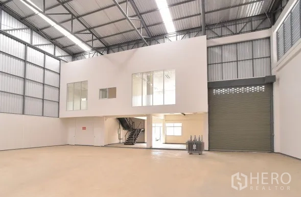 Factory for rent in Phra Nakhon Si Ayutthaya - Warehouse bay with mezzanine office, large automatic roller shutter door and bright loading area.
