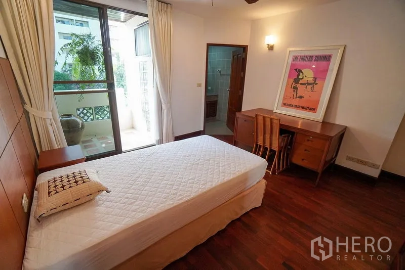 Apartment for rent in Watthana, Bangkok - Bright secondary bedroom with desk, private balcony and en-suite access.