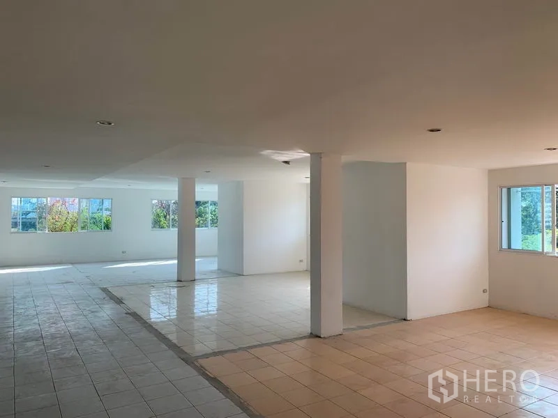 Office Space for rent in Huai Khwang, Bangkok - Large open-plan floor with broad windows, two exit doors and green views outside.