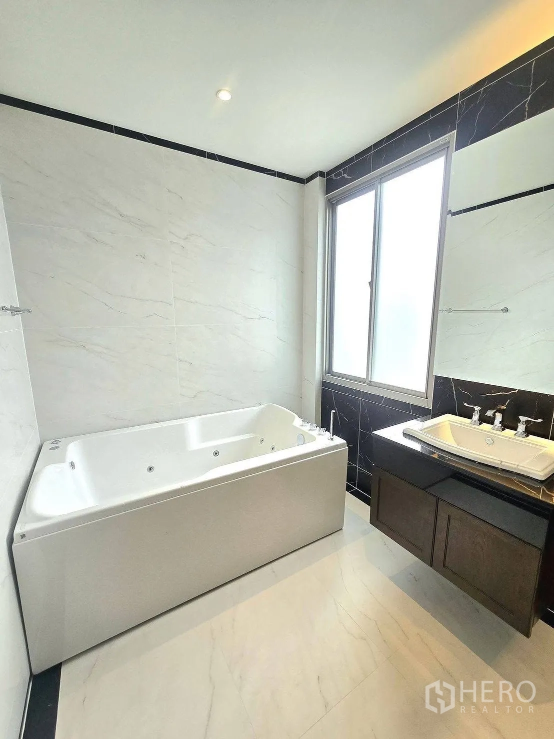 บ้านเดี่ยว for rent or sale in Bang Phli, Samut Prakan - ห้องน้ำสว่างสไตล์หรูพร้อมอ่างอาบน้ำจากุซซี่ ผนังลายหินอ่อน เคาน์เตอร์อ่างล้างหน้า และหน้าต่างฝ้า