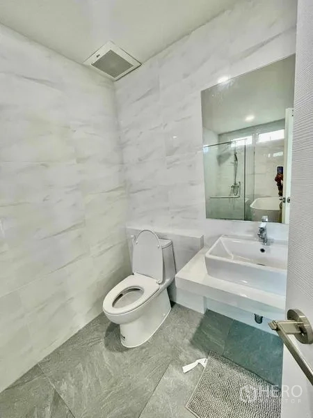 联排别墅 出租或出售在Prawet, Bangkok - 整洁的卫浴，仿大理石墙面、台盆与玻璃淋浴区。