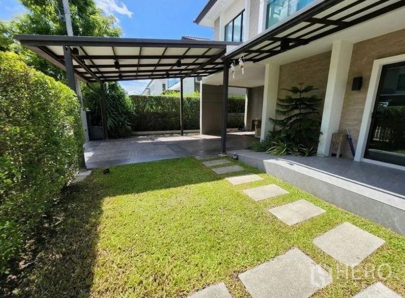 独立式住宅 出租在Prawet, Bangkok - 前院草坪与踏步小径，带顶车棚与露台的曼谷Prawet区独栋别墅。