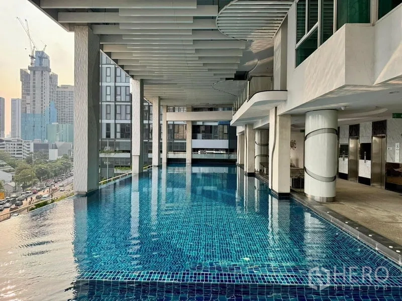 公寓 出售在Ratchathewi, Bangkok - 半室外无边泳池，城市景观与现代立柱。