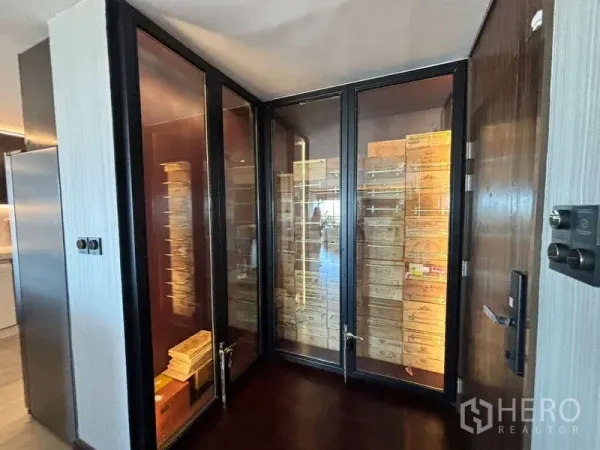 Condominium for rent in Watthana, Bangkok - Glass-enclosed storage room with wooden shelving and boxes inside a luxury condo.