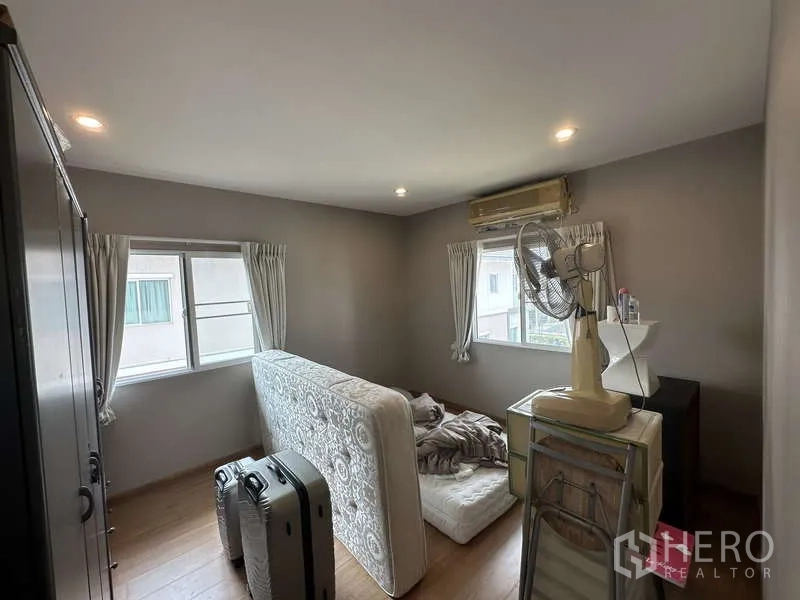 Detached House for sale in Sai Mai, Bangkok - Secondary bedroom with two windows and wood flooring.