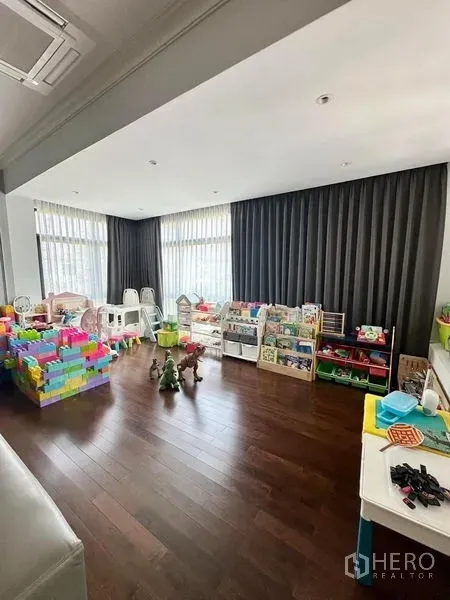 独立式住宅 出售 - 采光充足的游戏室，落地窗、深色窗帘与玩具收纳。