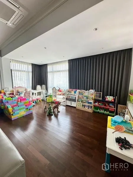 独立式住宅 出售 - 采光充足的游戏室，落地窗、深色窗帘与玩具收纳。