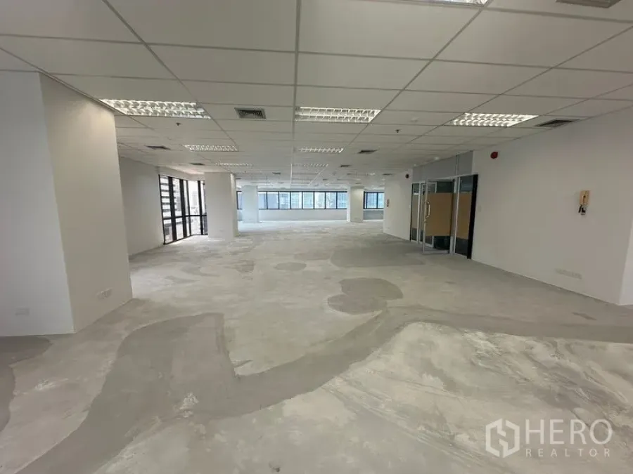 Office Space for rent in Bang Rak, Bangkok - Unfurnished office floor with grid ceiling, recessed lighting and glass entry doors.