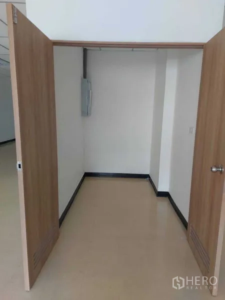 Office Space for rent in Pathum Wan, Bangkok - Compact storage or server nook with double wooden doors and an electrical panel inside an office.