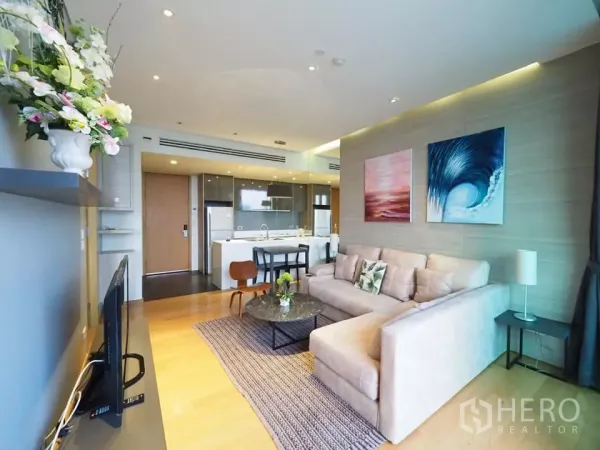 คอนโด ให้เช่าในWatthana, Bangkok - ห้องนั่งเล่นโปร่งสว่าง โซฟาเข้ามุม งานศิลปะผนัง และครัวสมัยใหม่ในคอนโดย่านทองหล่อ วัฒนา กรุงเทพฯ