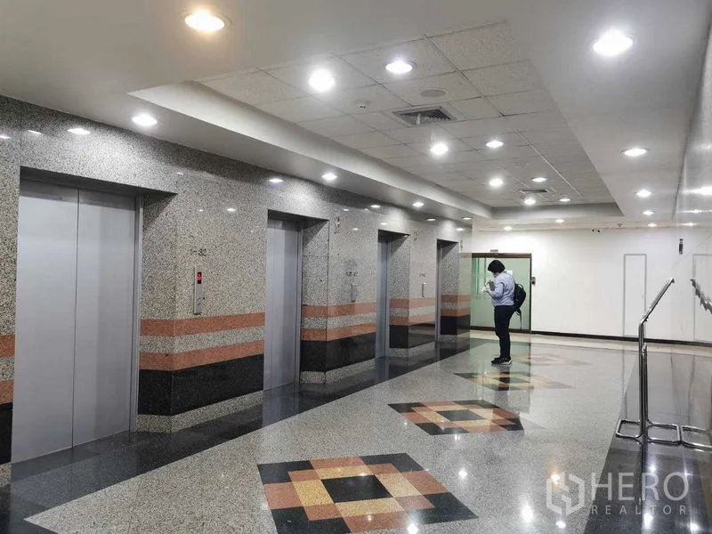 สำนักงาน ให้เช่าในWatthana, Bangkok - โถงลิฟต์สมัยใหม่ มีลิฟต์หลายตัวและผนังหินแกรนิตเงา.