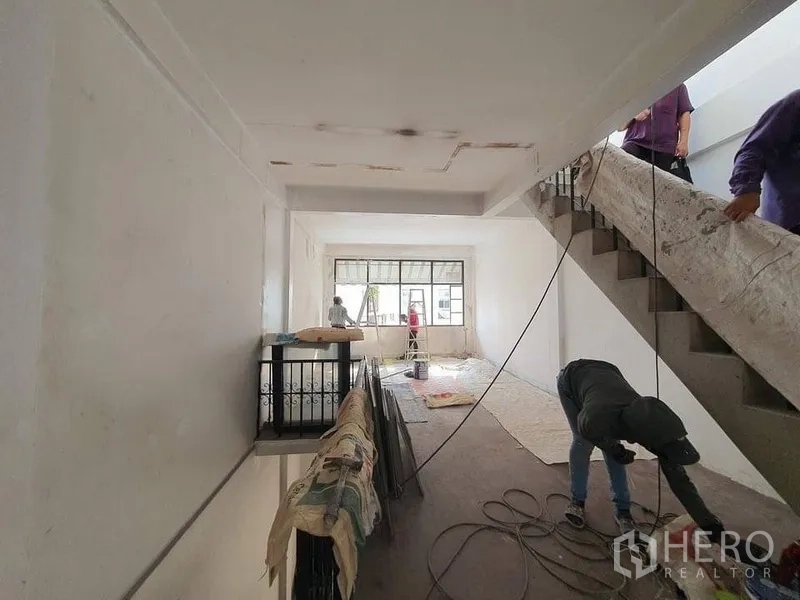 Shophouse for rent in Bangkok - Interior corridor with staircase and large front windows inside a multi-storey shophouse.