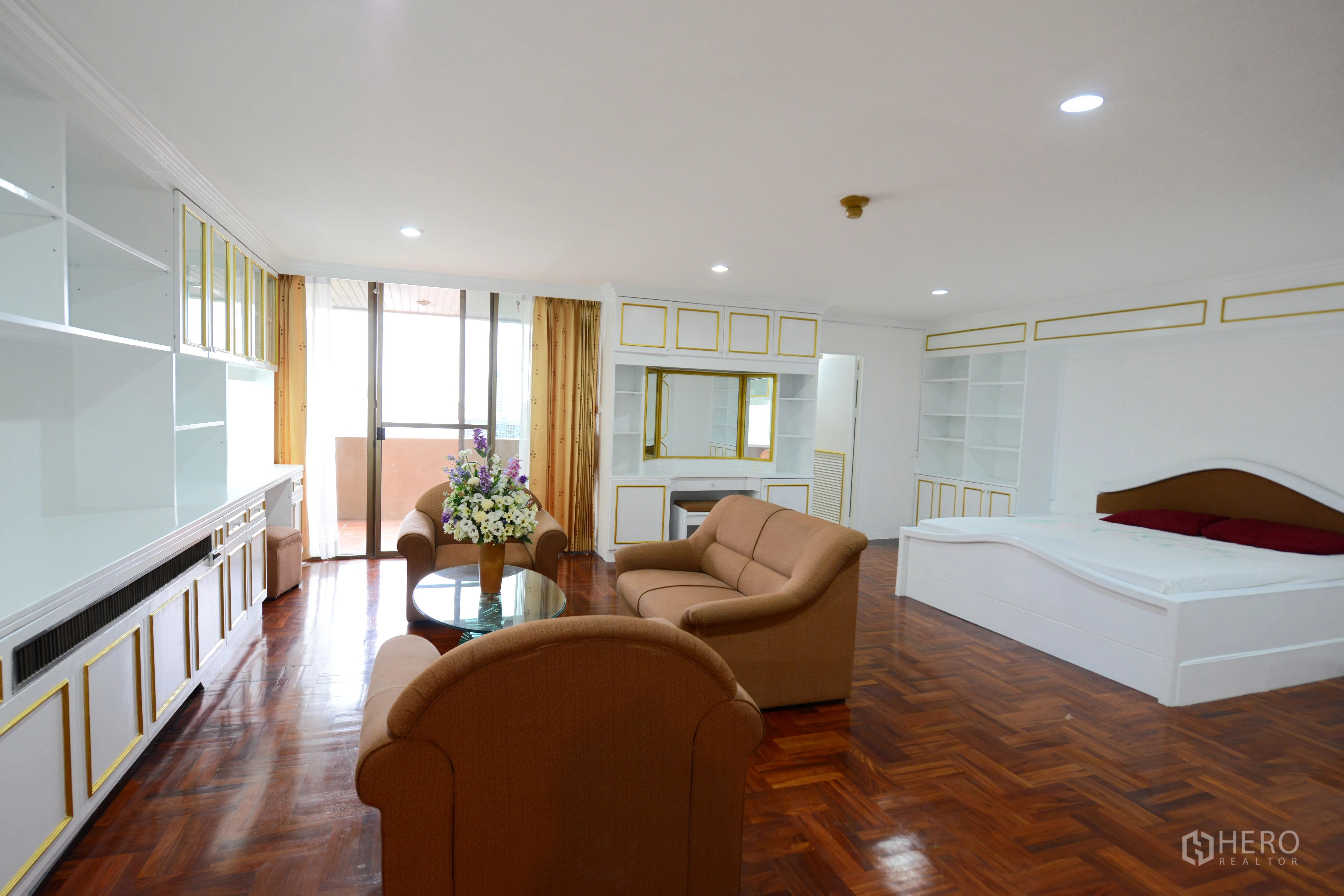 Condominium for rent or sale in Watthana, Bangkok - Master suite with lounge area, sliding doors to balcony and extensive built-in shelving