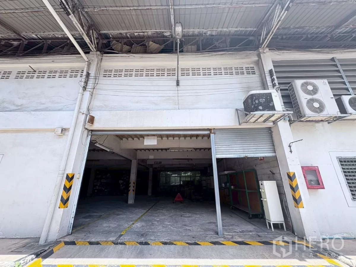 工厂 出租或出售在Bang Khun Thian, Bangkok - 装卸区，卷闸门、空调机组与斜坡入口。