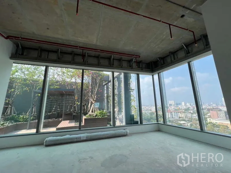 办公空间 出租在Phaya Thai, Bangkok - 转角办公区，落地玻璃直面景观屋顶花园与城市全景。
