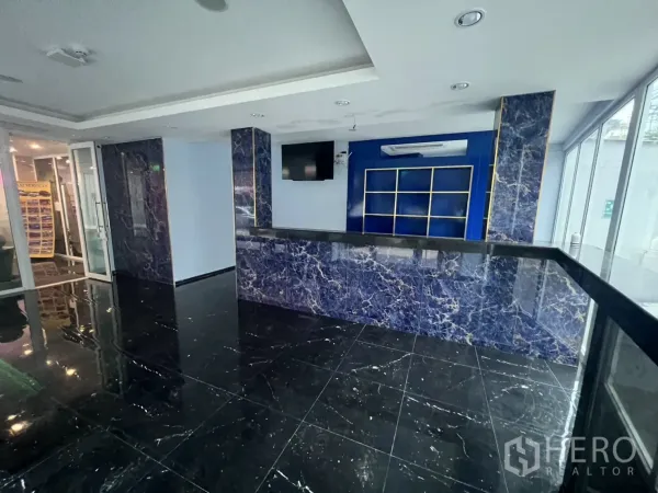 Retail Space for rent in Khlong Toei, Bangkok - Service counter with blue feature wall, built-in shelving and wide glass frontage.