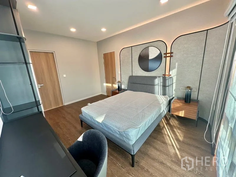 Detached House for rent in Samut Prakan - Bedroom with designer headboard feature wall, desk and abundant natural light.