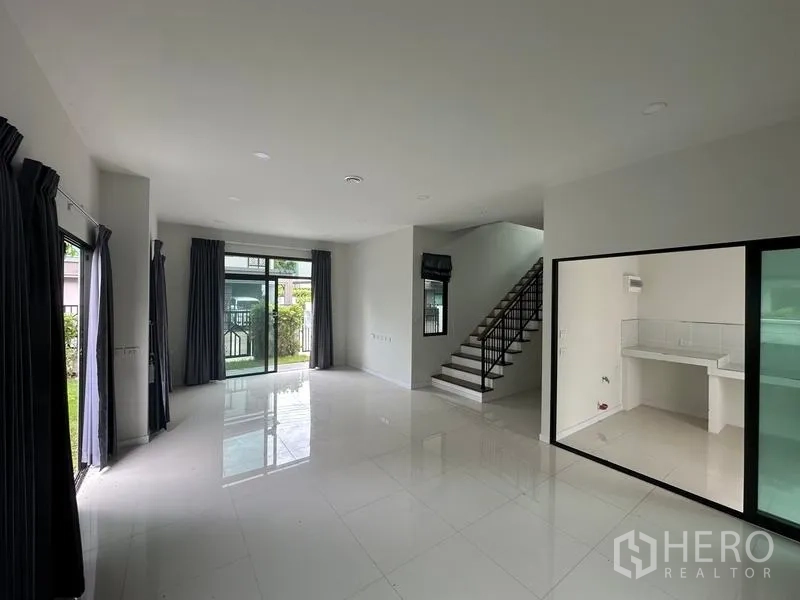 独立式住宅 出售在Khlong Sam Wa, Bangkok - 客餐厅连楼梯，玻璃隔断的厨房