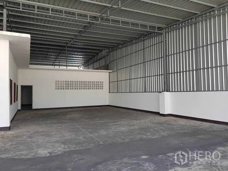 Warehouse for rent in Nong Khaem, Bangkok - Covered loading bay with metal cladding and concrete floor.
