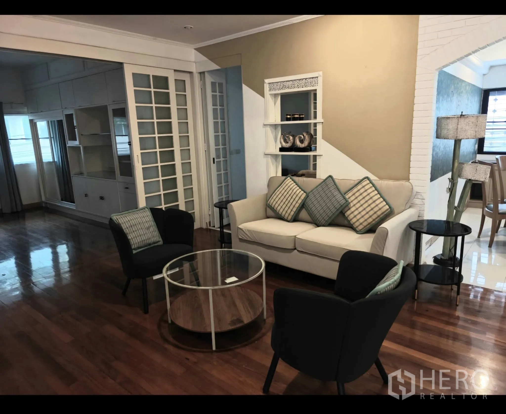 公寓 for rent in Sathon, Bangkok - 客厅配沙发与玻璃茶几，实木地板并设玻璃推拉隔断。