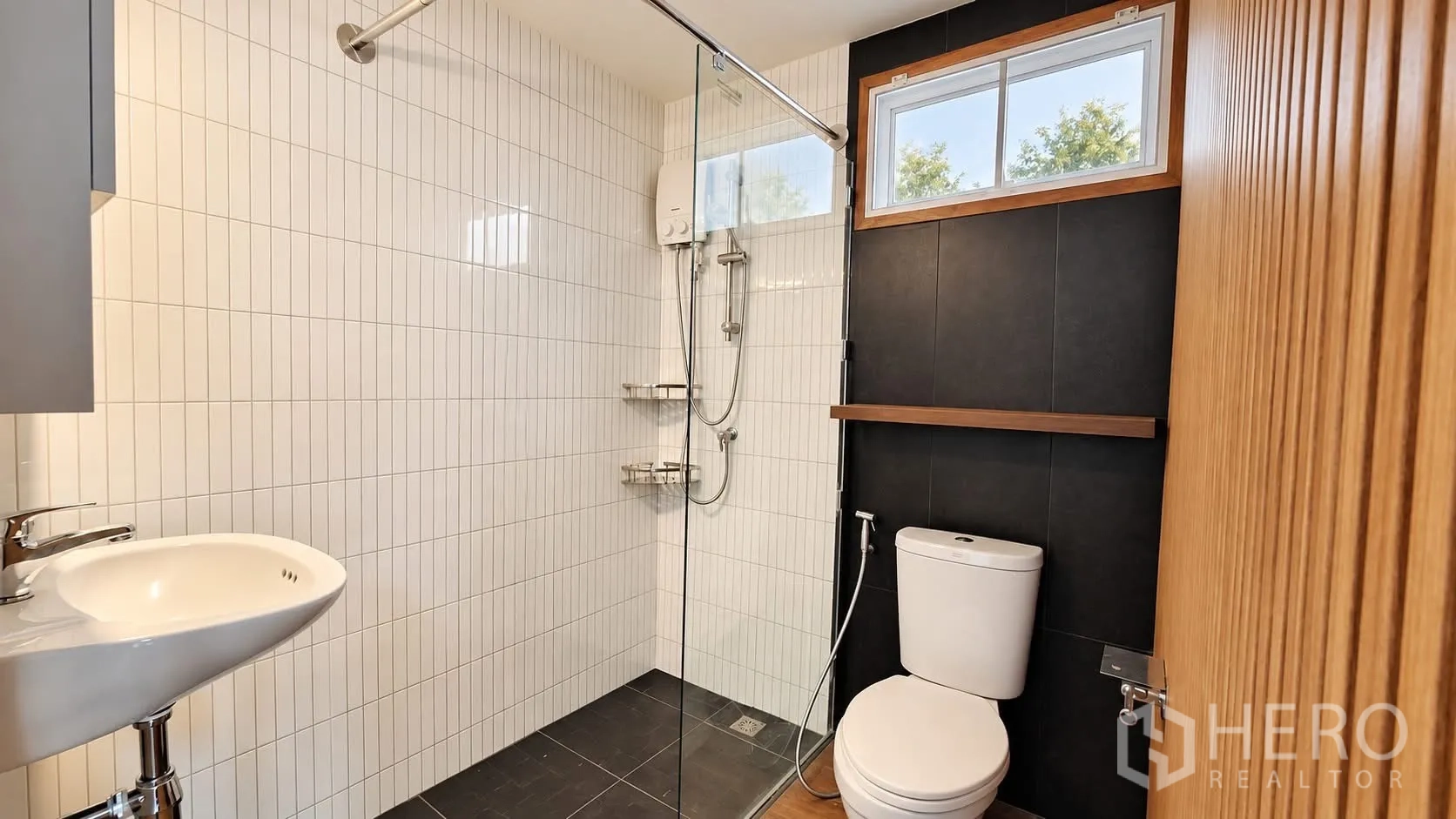 บ้านเดี่ยว for rent in Khlong Toei, Bangkok - ห้องน้ำพร้อมโซนอาบน้ำแบบกระจกกั้น โถสุขภัณฑ์ และกระเบื้องลายเส้นสีขาวตัดผนังสีเข้ม