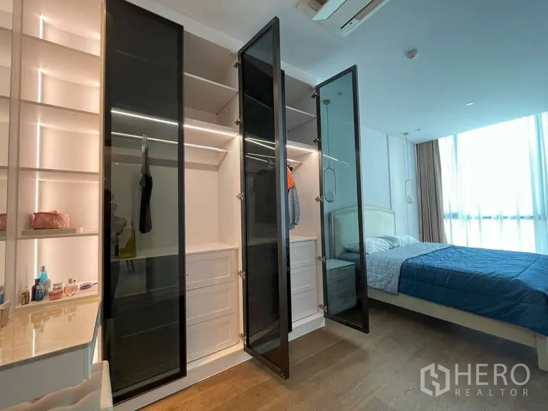Condominium for rent or sale in Sathon, Bangkok - Walk-in wardrobe with glass doors, LED shelving and a dressing nook beside the bedroom.