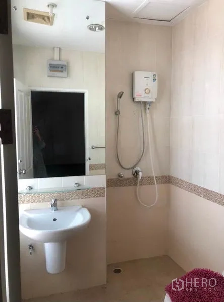 Townhouse for rent in Chatuchak, Bangkok - Bright bathroom with mirror, water-heater shower and basin.