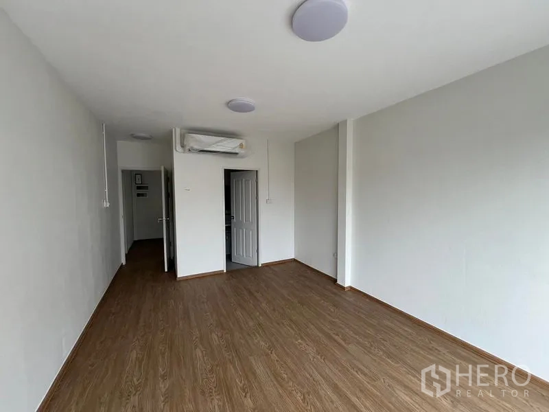 带办公室的家 出租在Huai Khwang, Bangkok - 采光良好的卧室，木地板，装有空调与通向卫生间/走廊的门。