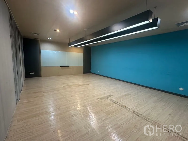 Office Space for rent in Bang Rak, Bangkok - Training or meeting room with long pendant lights and a blue feature wall.