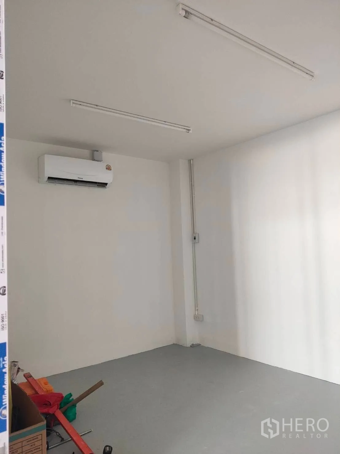 Warehouse for rent in Lat Phrao, Bangkok - Compact office room with air-conditioning unit and overhead strip lights.