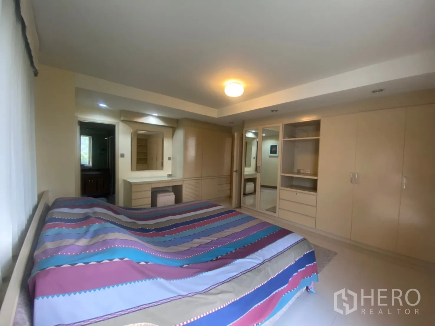 Condominium for rent in Phaya Thai, Bangkok - Master bedroom with built-in wardrobes, dressing table, and ample storage.