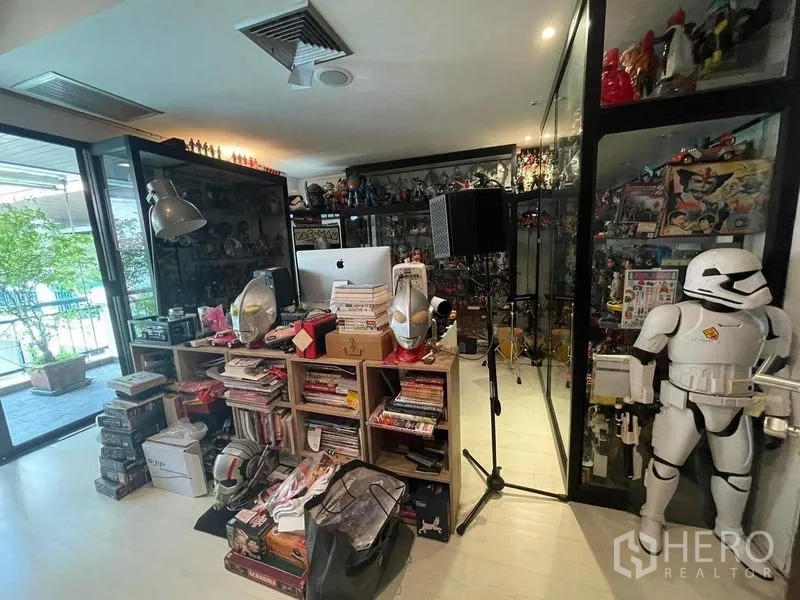 Townhouse for sale - Collector’s room with glass display cases and access to a terrace.
