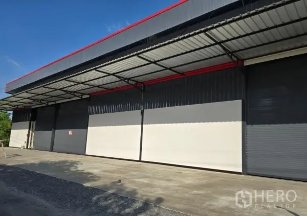 Warehouse for rent in Khlong Sam Wa, Bangkok - Modern warehouse exterior with wide covered loading bays and roller shutters in Khlong Sam Wa, Bangkok.