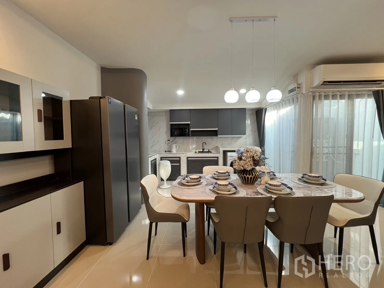 联排别墅 for rent in Bang Phli, Samut Prakan - 六人位大理石餐桌，旁有对开门冰箱与储物柜。