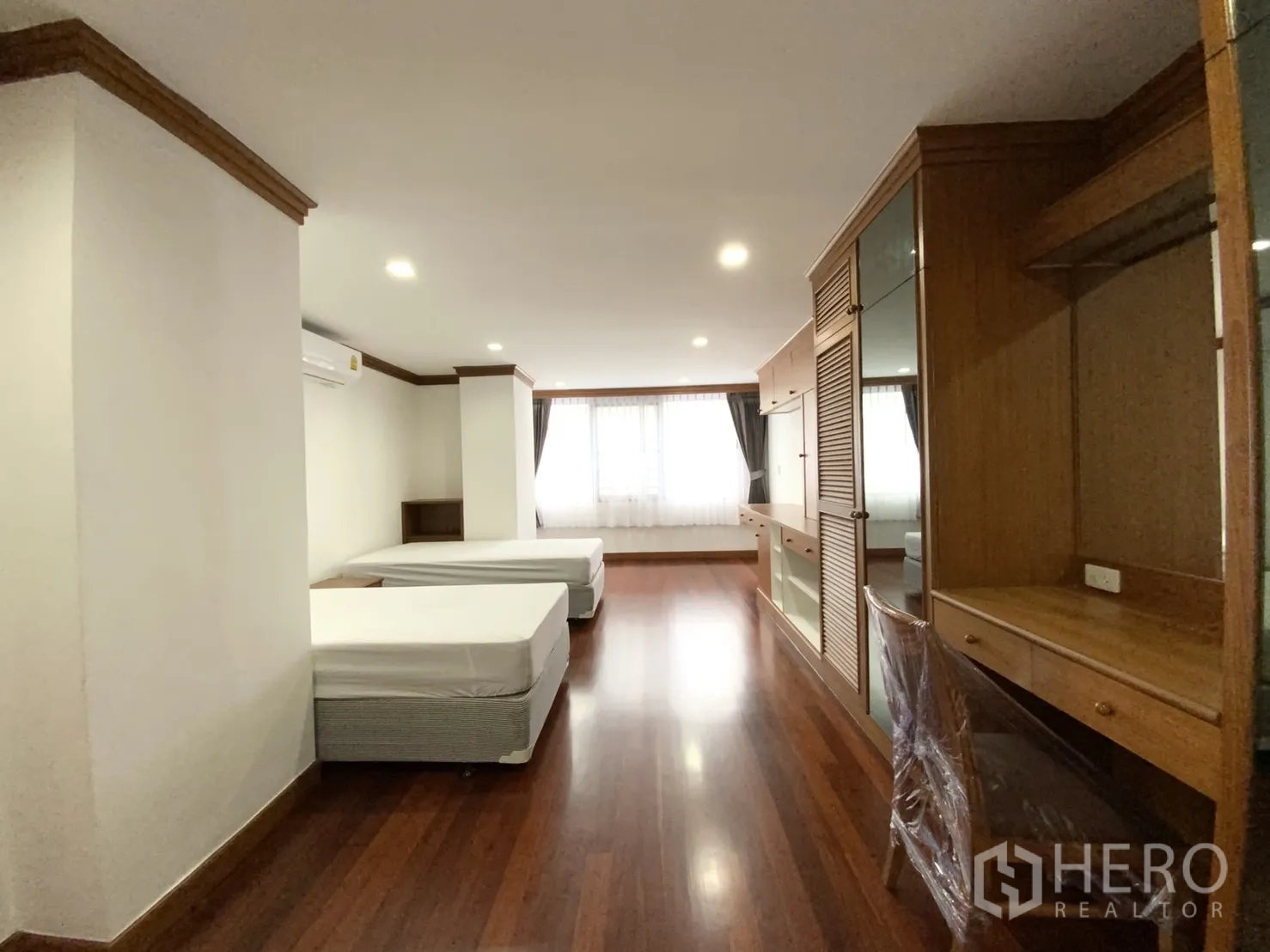 公寓 出租在Watthana, Bangkok - 双床卧室另一视角，带书桌、衣柜与大窗。